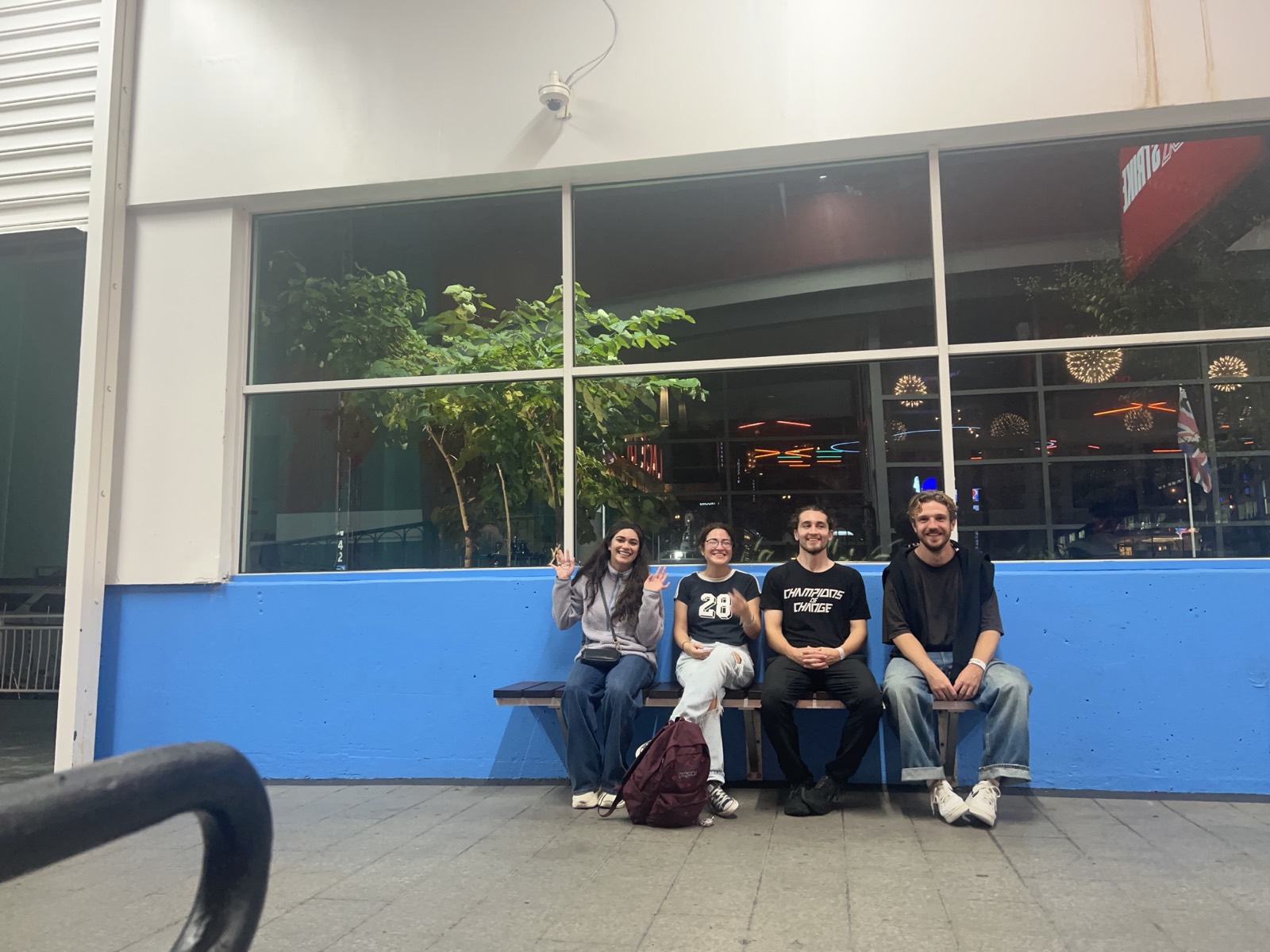 Four of us on a bench outside afterwards, waving at the camera.
