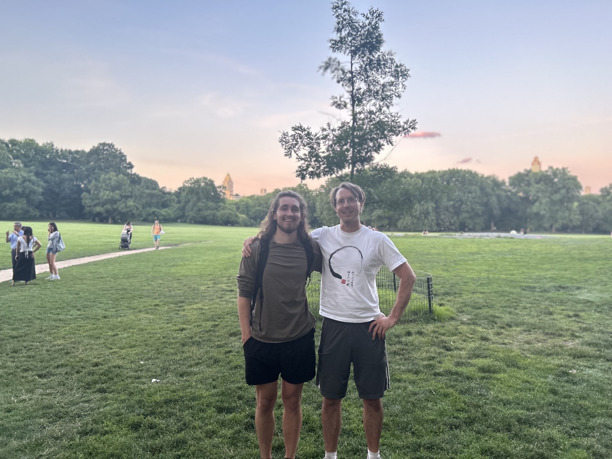 Two friends arm-in-arm at sunset in the park