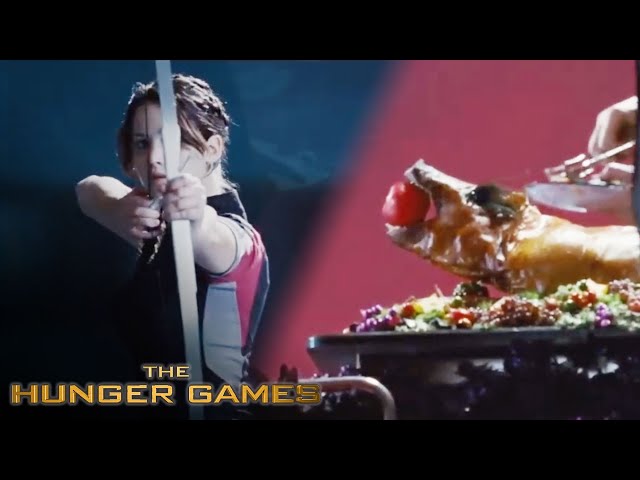 Katniss drawing her bow at the assessors' banquet table, the arrow pointed at the apple in the roast pig's mouth